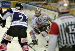 Martin Steinegger vom EHC Biel (Mitte) und Alessandro Chieso vom EV Zug kämpfen um den Puck. (Bild: Keystone)