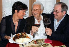 Monika Fasnacht serviert Walter Roderer ein Ochsenschwanz-Ragout, Vic Eugster (rechts) prostet zu. (Bild: Archiv Neue LZ)