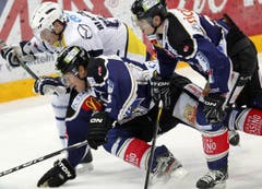 Die Zuger Timo Helbling, links, und Patrick Fischer, rechts, im Kampf gegen Mattia Bianchu von Ambri.
