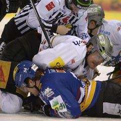 Biels Verteidiger Claudio Cadonau und Zugs Verteidiger Alessandro Chiesa sowie Linesman Joris Müller (von unten nach oben) üben sich im Bodenkampf. (Bild: Keystone)