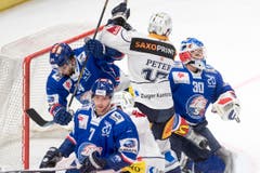 ZSC-Spieler Phil Baltisberger, links, und Torhüter Lukas Flüeler, rechts, verteidigen gegen Emanuel Peter. (Bild: Urs Flüeler/Keystone)