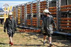 Geschützt gegen Fettspritzer: Zwei Helfer liefern Nachschub am Spiess. (Bild: Swiss Images / Michael Buholzer)