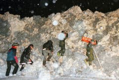 Es ist der 22. Februar 1999. Rettungskräfte versuchen um 2 Uhr morgens die Schneewand in Evolène zu durchbrechen. Eine Lawine hat den Skiort am Tag zuvor erschüttert und zahlreiche Chalets zerstört. Zu diesem Zeitpunkt sind zwei Menschen verstorben, zehn werden noch vermisst. (Bild: Keystone/Fabrice Coffrini)