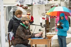 Guerilla-Aktion: Die Redaktion der "Ostschweiz am Sonntag" liest am Sonntagsverkauf aus dem E-Paper vor. Ort: Aepliplatz, 9000 Sankt Gallen. (Bild: Hanspeter Schiess)