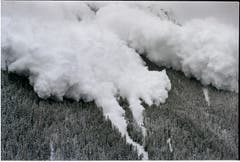 Eine mächtige Staub-Lawine donnert am 22. Februar 1999 neben dem Skigebiet Evolène, in den Schweizer Alpen, ins Tal runter. Einen Tag, nachdem eine Lawine in Evolène 12 Todesopfer gefordert hatte. Der heftigen Schneefälle wegen, haben sich bereits zahlreiche Lawinen spontan ausgelöst und töteten alleine im Monat Februar 19 Menschen. (Bild: Keystone/Fabrice Coffrin)