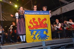 Die Ehrendamen Fabienne Häne, Lorena Segmüller und Martina Häne (von links) enthüllen die neue Vereinsfahne der Blechharmonie Kirchberg.Bilder: Beat Lanzendorfer (Bild: Beat Lanzendorfer)