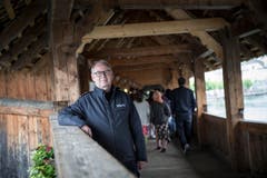 Feuerwehrkommandant Theo Honermann zeigt Brandschutzmassnahmen auf der Kapellbrücke. Im Hintergrund, kaum sichtbar, die Videokameras. (Bild: Manuela Jans-Koch (Luzern, 3. Mai 2018))
