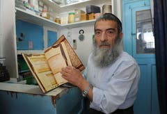 Jüdisches Pilgerfest zur Ghriba-Synagoge auf der Insel Djerba - Tunesiens Oberrabbiner Haim Bittan in seinem kleinen Laden mit einem Buch über die Geschichte des tunsischen Rabbinats.(Fotografin: Katharina Eglau)