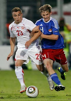 Switzerland's Xherdan Shaqiri, left, fights for the ball with Liechtenstein's Martin Rechsteiner, right, during a friendly soccer match between Liechtenstein and Switzerland at the Rheinpark Stadium in Vaduz, Liechtenstein, Wednesday, August 10, 2011. (KEYSTONE/Peter Klaunzer)