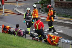 Die Brandbekämpfung unter Atemschutz wie am Donnerstagabend im Linsebühl ist härtester Körpereinsatz. Was man den Feuerwehrleuten nach dem Einsatz auch ansieht: Kurze Pause auf der Singenbergstrasse. (Bild: Reto Voneschen)