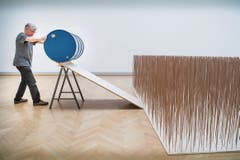 Roman Signer ist bereit, die Holzstäbe mit dem blauen Fass niederzumähen. (Bild: Ralph Ribi)