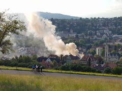 Spaziergänger und Velofahrer auf der Dreilindenstrasse schauen alarmiert Richtung Stadt. Rechts im Bild die Kirche Linsebühl mit ihrem markanten Turm. (Bild: Sabine Rüthemann)