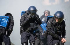 Bei der Übung der Polizeikorps von Luzern, Nid- und Obwalden in Schüpfheim schützen sich Polizisten vor Tränengas (Bild Corinne Glanzmann, 25. Mai 2018).