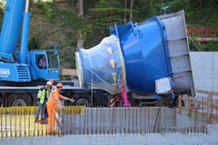 Nachdem am Grund des Rohbaus die letzten Vorbereitungsarbeiten erledigt sind, wird die 17 Tonnen schwere Turbine langsam in die Baugrube gesenkt.