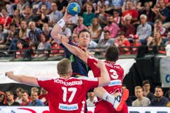 Die Schweizer Samuel Röthlisberger (links) und Lucas Meister (rechts) verteidigen gegen den Norweger Sander Sagosen. (Bild: Keystone/Alexandra Wey)