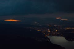 Die untergehende Sonne spiegelt sich in den Mittellandseen. Wie leuchtende Augen erhellen sie die bereits dunkle Umgebung. (Bild: Guido Bertuzzi)