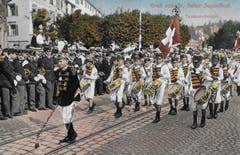 Tambouren vor 1914 auf dem Burggraben. Links am Strassenrand die Kadettenmusik, dahinter die Abzweigung der Glocken- in Richtung Brühlgasse mit dem Gebäude und dem Biergarten des Restaurants «Zur Harfe».