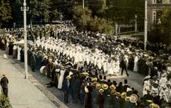 Der Kinderfest-Umzug um 1913: Die Mädchenklasse samt Blasmusik dahinter kommen aus dem Kantipärklein auf den Burggraben. Am rechten oberen Bildrand ist eine Ecke des Gebäudes der Kantonsschule am Burggraben zu erkennen.