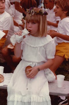 Zwischen Tradition und Erneuerung: 1983 lässt sich ein Mädchen im weissen Spitzenkleid seine Kinderfest-Bratwurst schmecken. (Bild: Stadtarchiv der Ortsbürgergemeinde St.Gallen/Sammlung Foto Gross)
