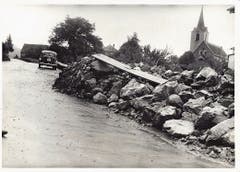 Steine türmen sich nach dem Unwetter auf der Staatsstrasse vor der Kirche. (Bild: Staatsarchiv SG)