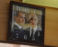 In der Metzgerei Muheim zeigt diese Uhr die Zeit an, hinterlegt mit einem Bild von Dimitri Medwedew und Vladimir Putin. (Bild: Urs Hanhart (Andermatt, 8. Juni 2018))