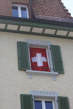 Die Schweizer Fahne als Vorhang im Fenster eines Hauses an der Gerbestrasse in der Lachen.