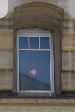 Die Intensität der Sympathie hängt nicht von der Grösse des Fahnentuchs ab: Schweizer Fähnli im Fenster eines Hauses an der Zürcher Strasse in der Lachen.