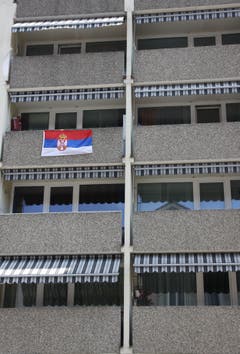 Farbtupfer an einer grauen Hausfassade an der Feldlistrasse: die serbische Flagge.