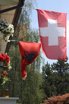 Viele Albanerinnen und Albaner fiebern an dieser WM mit der Schweizer Nati mit. Eine albanische und eine Schweizer Fahne in einem Garten an der Fürstenlandstrasse.