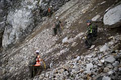 Gebirgsspezialisten und Kampfmittelbeseitiger suchen nach Munitionsschrott und Blindgängern. (Bild: Keystone/Gian Ehrenzeller)