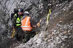 Oberwachtmeister Benjamin Rohner (links) und ein Gebirgsspezialist markieren einen Blindgänger. Bild: (Keystone/Gian Ehrenzeller)
