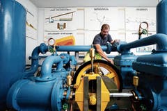 Betriebsleiter Thomas Horat mit der 100-jährigen Kolbenpumpe. (Bild: Stefan Kaiser (Baar, 6. Juni 2018))