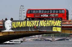 Amnesty International hat über die Vauxhall Brücke ein langes Banner mit den Worten «Der Albtraum der Menschenrechte» mit Trumps Konterfei gehisst. (Bild: AP Photo/Luca Bruno)