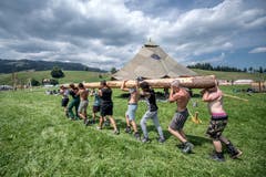 Mit vereinter Kraft werden die Baumstämme für die Bauten an die richtige Stelle getragen. (Bild: Pius Amrein (Escholzmatt, 12. Juli 2018))