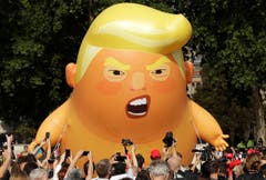 Die Demonstranten machten ihrem Unmut auch über eine sechs Meter hohe aufblasbare Trump-Figur Luft. (Bild: AP Photo/Matt Dunham)