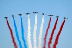 Farbenfrohe Panne am französischen Nationalfeiertag: Einer der Kampfjets hatte rote statt blaue Farbe geladen. Anstelle der erwarteten Tricolore entstand so ein rot-blau-weiß-roter Streifen am Pariser Himmel. (Bild: AP Photo/Francois Mori)