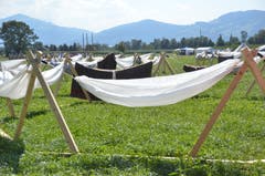 Eine Schar schläft unter freiem Himmel in Hängematten.