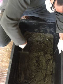 Am einfachsten klappt das Betonieren mit Easy-fix-Beton, der direkt in einen Mischbehälter geschüttet und nur noch mit Wasser angerührt werden muss. Die Wassermenge ist auf der Packung angegeben. Wichtig ist, alles gut zu durchmischen. Atemschutz und Handschuhe sind für diesen Schritt zu empfehlen. (Bild: Migros)