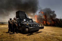 Sicherheitskräfte brennen ein Schilffeld am Fluss Tigris ab, in welchem der IS Munition versteckt hat. (Bild: Philipp Schmidli (Mossul, 14. Juli 2018))