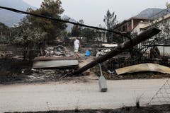 Ein Mann sucht nach seinen Habseligkeiten in Kineta (AP Photo/Yorgos Karahalis, 24. Juli 2018)