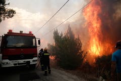Feuerwehrmännder versuchen in Neo Voutsa, einem Vorort von Athen, ein Waldbrand zu löschen. (Bild: EPA/ Alexandros Vlachos (23. Juli 2018))