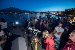 In Luzern wird das Spektakel am Vierwaldstättersee verfolgt (Bild: Urs Flüeler / Keystone)