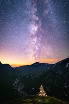 Auf dem Pass Diesrut (2428m) mit Blick auf die Greinaebene und dem mäandrierenden Fluss. Ein Steinmännchen bildet den passenden Vordergrund, während die Milchstrasse den Nachthimmel erhellt. (Bild: Adrian Steg)