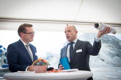 Regierungsrat Benedikt Würth hilft Markus Sauerbruch (rechts), Leiter der Stadler-Division Schweiz, beim Verpacken der Baupläne in eine Hülse für den Spatenstich.