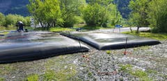Die gefüllten Entwässerungsschläuche liegen noch immer zum Trocknen am Ufer des Sees.
