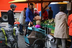 Mit Kind und Kegel an den Bauernmarkt: junge Väter und ihre Sprösslinge vor der Gemüse-Auslage.
