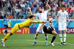 Der französische Torhüter Hugo Lloris und Uruguays Cristhian Stuani (blaues Trikot) kämpfem um den Ball. (AP Photo/David Vincent, Nizhny Novgorod, 6. Juli 2018)