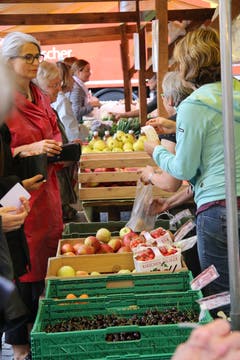Kundinnen und Verkäuferinnen vor der Auslage mit Obst aus Lömmenschwil.