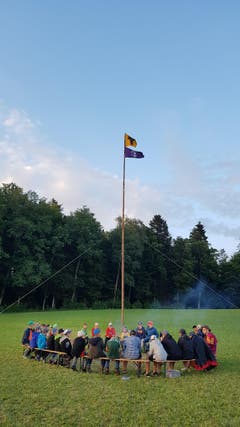 Die ganze Schülerschaft der Pfadi St. Martin sitzt gemütlich beisammen am Feuer in Schongau. Zuvor hielten die Kinder ein Quidditchtunier ab. (Bild: Bastian Marxen)