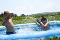 Die heissen Temperaturen erfordern eine gehörige Abkühlung. Silvan Peter und Colin Widmer von der Jungwacht Sins wissen, wie das geht. (Bild: Jakob Ineichen, Schmiedrued, 8. Juli 2018)
